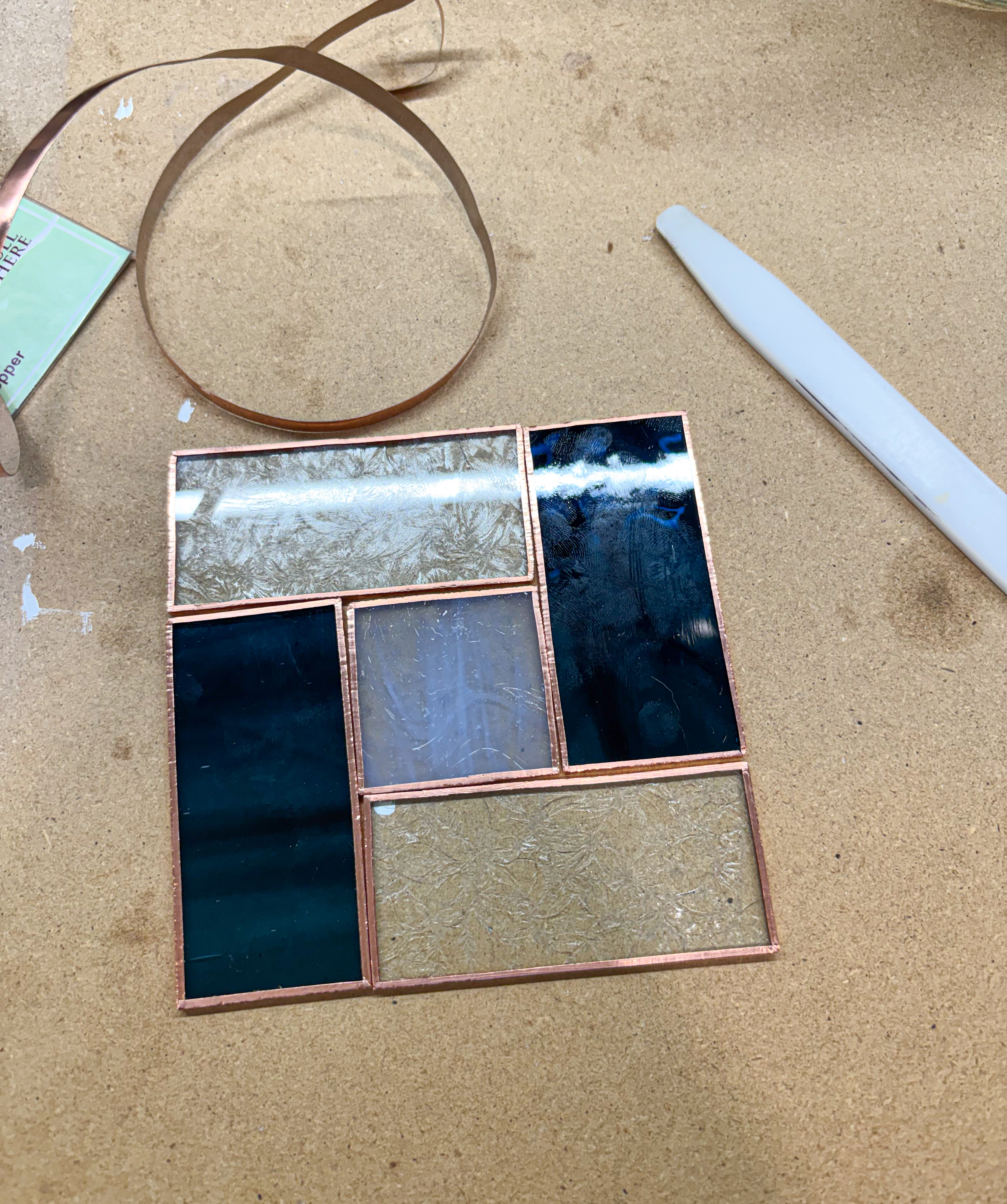Glass pieces wrapped in copper foil with a roll of copper tape