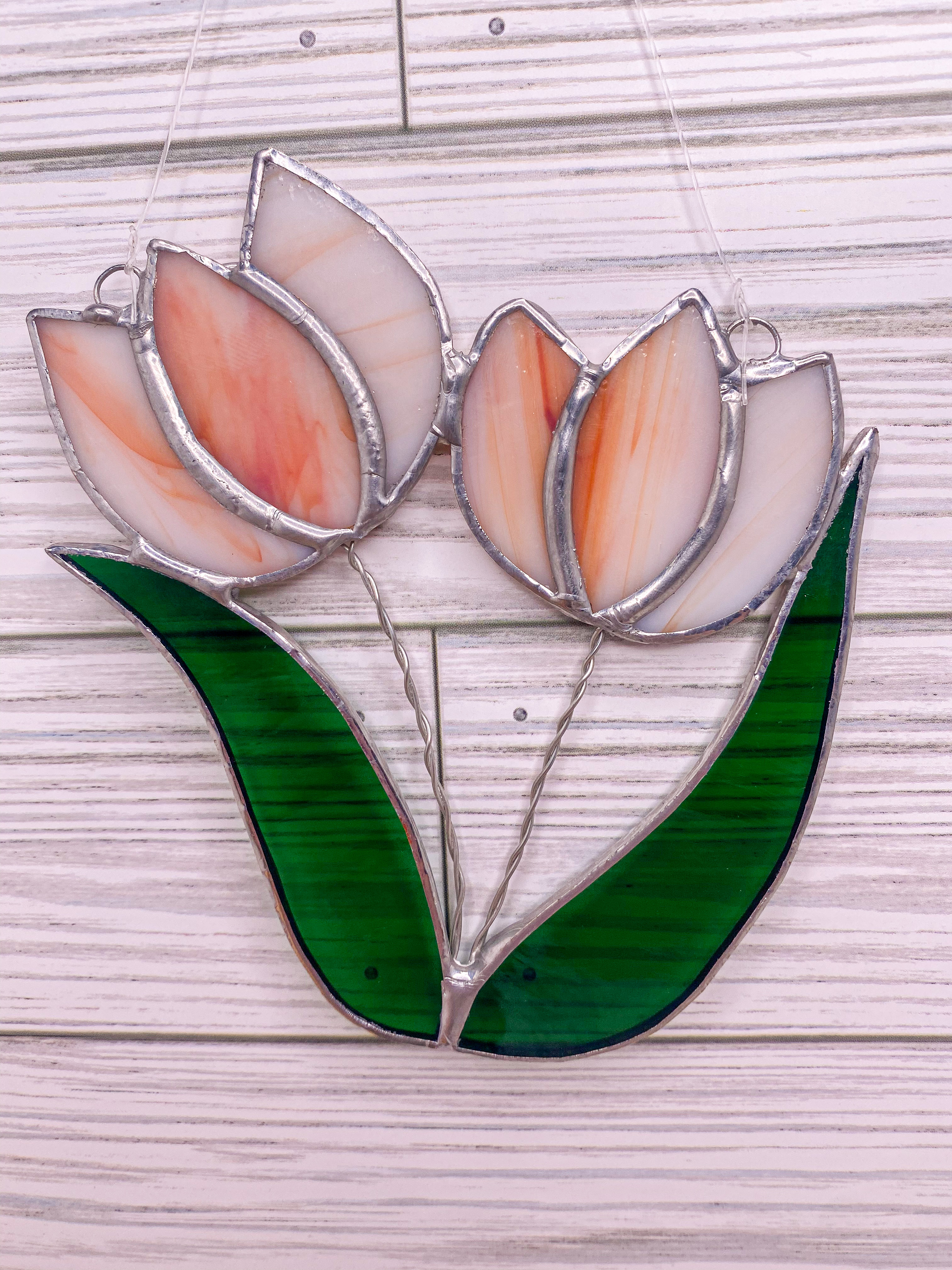 Two peach tulips with green leaves, in stained glass